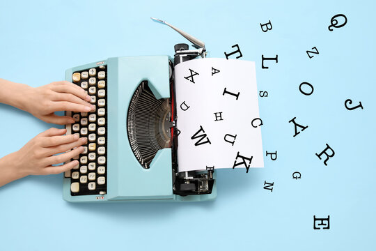 Woman typing on typewriter with blank paper sheet on blue background