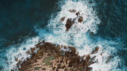 Ocean waves swirl and crash around rocky islands in a dramatic aerial perspective - Powered by Adobe
