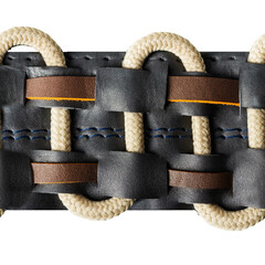 Seamless isolated photo of black leather straps with ornate braided rope inserts.