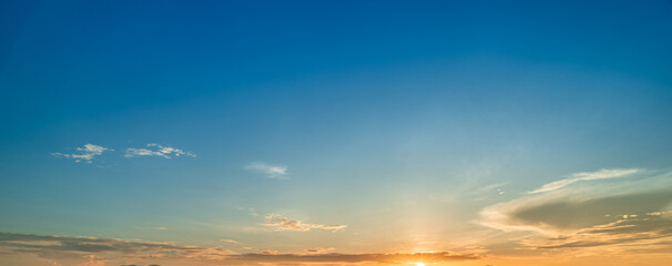 Bright sunrise sky with warm golden light and smooth blue-to-orange gradient.