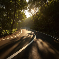 Fototapeta premium Winding asphalt road curves through sunlit forest with rays filtering between trees creating warm shadows and serene atmosphere
