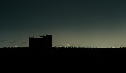 Fototapeta premium City skyline silhouette at night in Ukraine during blackout with minimal distant lights