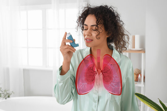 Young African-American woman using asthma inhaler in bathroom - Powered by Adobe