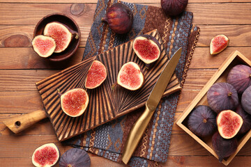 Board and box with fresh ripe figs on wooden background
