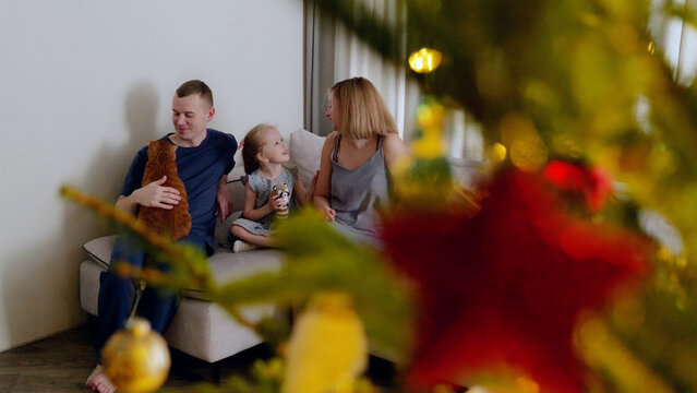 Family enjoying christmas in a cozy living room, with a decorated tree adding warmth and magic to their time together. Night before Christmas. New Year's Eve with family - Powered by Adobe