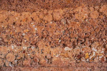 Full frame shot of rough earthen wall texture. These walls are constructed by ramming a mixture of aggregates, including gravel, sand, silt and a small amount of clay.