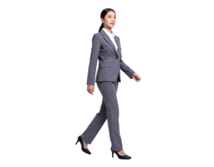 Confident young businesswoman walking with purpose in a professional grey suit.