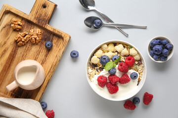 Bowl with healthy cornflakes, yogurt and berries on white background
