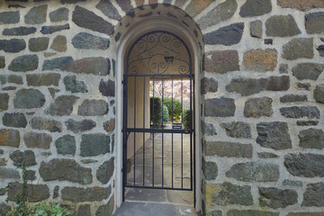 Arched doorway in a stone wall with a steel gate