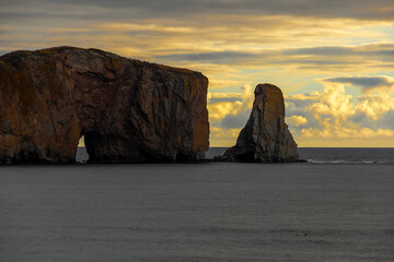 Breathtaking sunrise over Perce Rock, Gaspe Peninsula, Quebec. Captured in stunning morning light, this iconic landmark offers a serene and picturesque view.