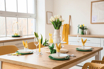 Dining table set for Easter with tulips in light kitchen