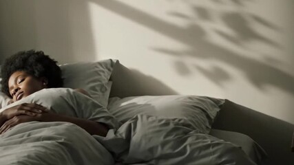 A peaceful black woman sleeping soundly, dreaming in her comfortable bed, enjoying a good night's rest