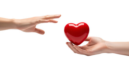 Fototapeta premium A red heart being offered from one hand to another against a black background in a studio shot