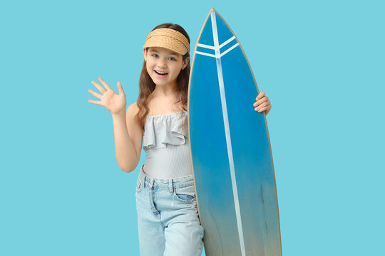 Happy girl with surfboard waving hand on blue background