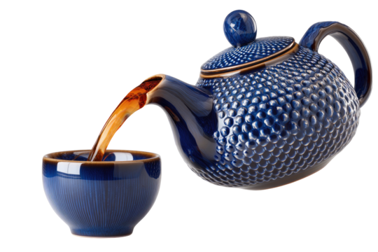 Textured blue teapot pours dark liquid into matching cup