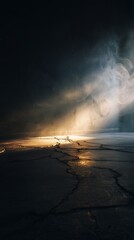 Dramatic light beam illuminates cracked ground with ethereal mist