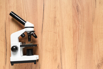 Modern microscope on wooden background