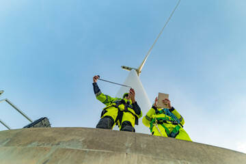 Team of engineers in reflective work suits join hands to inspect and demonstrate their work and...