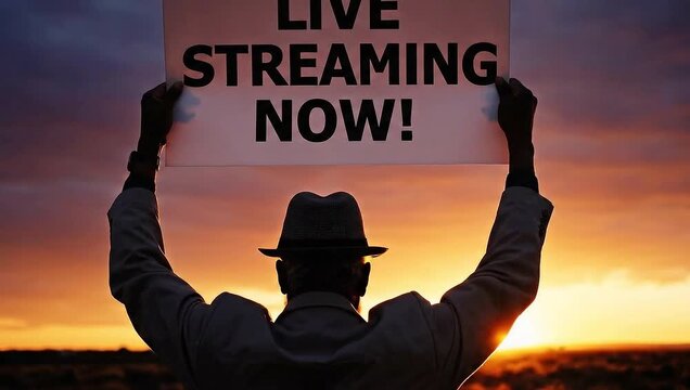 Person Holding Live Streaming Sign Against Sunset Sky.