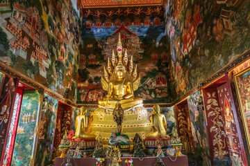 Buddha statue in colorful and intricately decorated temple of Wat Nak Prok, in Bangkok, Thailand.
