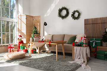 Interior of living room with sofa, table and Christmas gifts