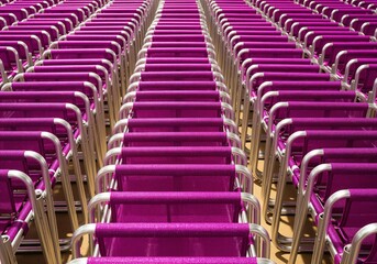 Obraz premium Massive stack of bright magenta folding chairs creating a strong repeating geometric pattern