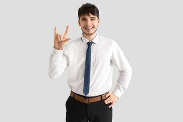 Young businessman using sign language on white background