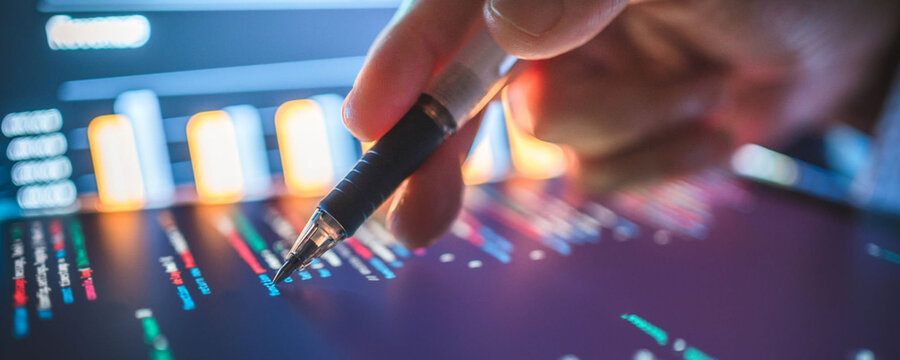 Analyzing financial data on a tablet with a stylus, close-up shot