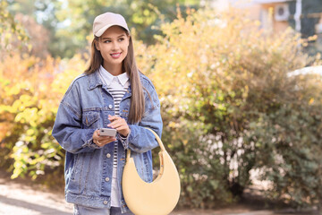 Young woman using mobile phone on street