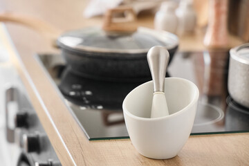 Mortar with pestle on counter in kitchen, closeup