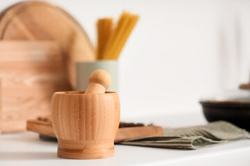 Wooden mortar with pestle on counter in kitchen, closeup