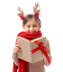 Cute little girl in Christmas reindeer horns reading book on white background