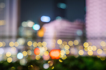 City street at night with bright neon lights and blurred car headlights glowing in vibrant colors, creating an energetic urban nightlife scene full of motion.