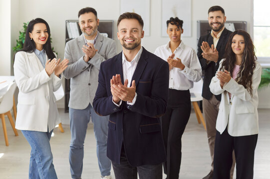 Business leader and happy team of employees applaud professional achievement standing in line at office. Applause of diversity group, corporate staff clapping. Leadership, corporate culture concept