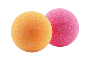 Two bath bomb spheres, orange and pink, on black