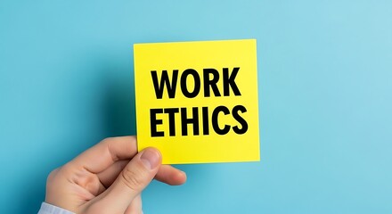 Hand holding a yellow sticky note with the words work ethics written in black text against a blue background