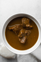 Overhead view of miyan kuka and tuwon on a white plate, top view of northern nigerian miyan kuka soup and rice swallow or tuwon shinkafa