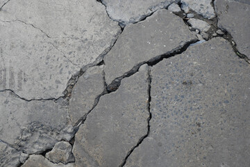 Fototapeta premium Cracked concrete surface showing signs of damage and wear