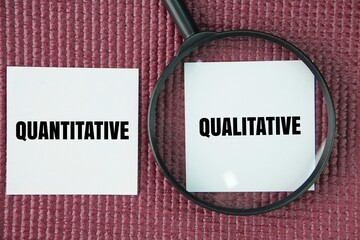 Magnifying glass and paper with the words quantitative and qualitative. two distinct types of...