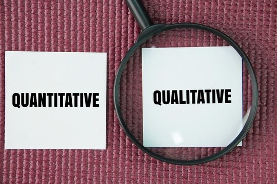 Magnifying glass and paper with the words quantitative and qualitative. two distinct types of research and data that differ in their approach and the kind of information they collect.
