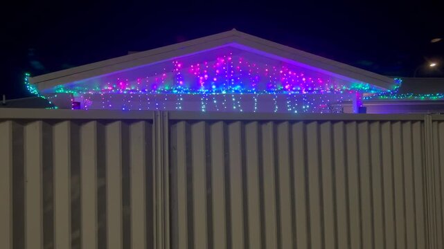 Colorful Christmas decoration lights on home roof lite light at night.