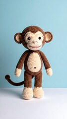 Amigurumi monkey standing against a pale blue background on a white surface, charming homemade look, brown and cream colors