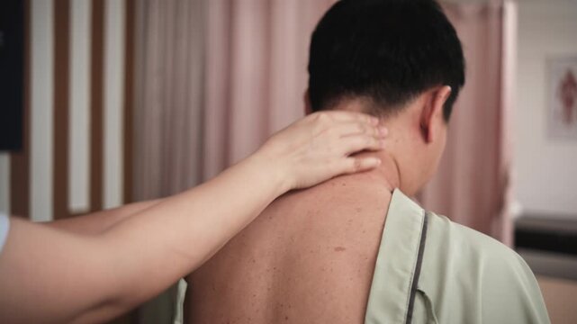 Close-up shot of Asian male patient is neck massaging, muscle stretching, treatment for health recovery for pain relief by physical therapist doctor, passive medical therapy at wellness spa clinic.