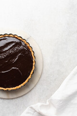 top view of chocolate filling in a baked pie shell, process of making chocolate tart