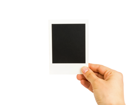 Hand holding blank polaroid frame photo isolated on black background on transparent background