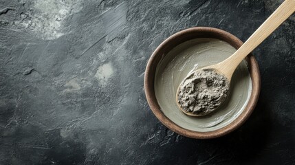 Clay Mask in Wooden Bowl with Spoon on Dark Surface