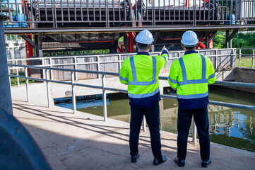 A professional engineer and an inspector are jointly seriously inspecting the water filtration of a...