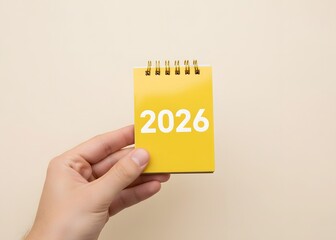 A man holds a notebook 2026 in his hands. Setting goals and objectives for the new year. Planning, business management and strategy concept. Trends, ideas and vision. New year 2026.