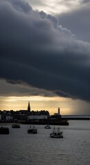 Fototapeta premium Dark storm clouds gather over a coastal town with fishing boats in the harbor