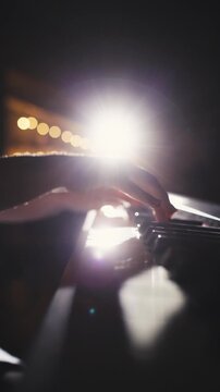 vertical slow motion macro shot of female pianist performing graceful movement on piano keys concept of creative passion art of sound focus and inspiration under warm studio light